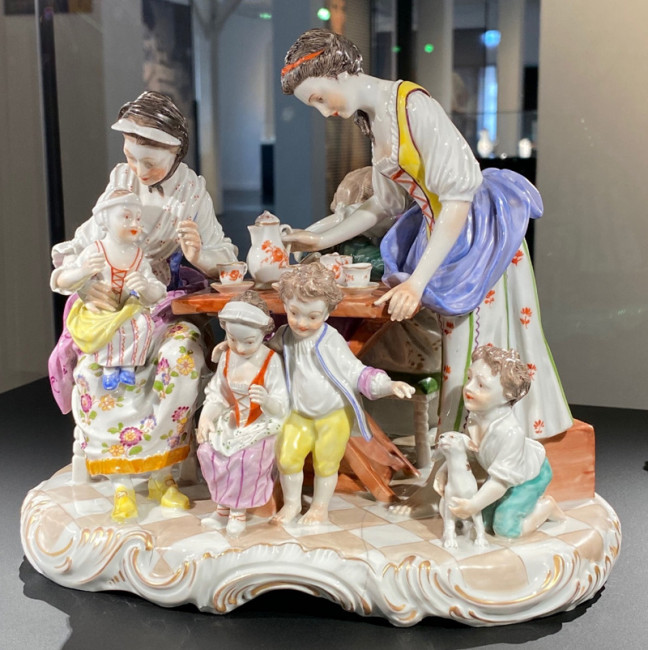 Porzellanfiguren arrangieren Teeparty-Szene mit Familie, Kindern und Hund, dekorativ bemalt. Fürstenberg Porzellan.