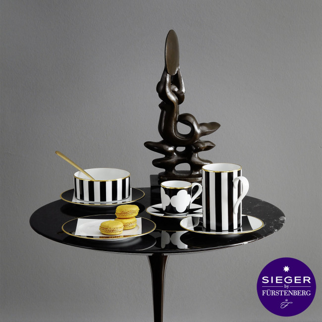 Schwarz-weiß gestreifte Tassen mit Macarons auf einem Tisch, moderne Skulptur. Fürstenberg Porzellan.