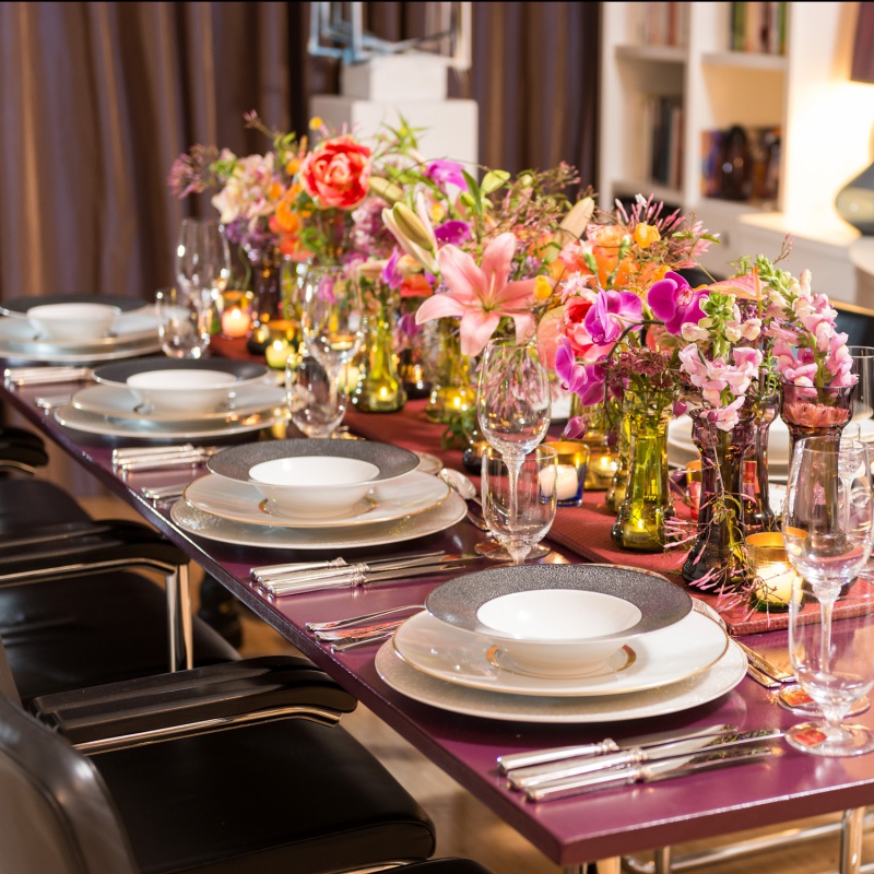 Elegant gedeckter Tisch mit Blumensträußen und Kerzen in festlicher Umgebung. Fürstenberg Porzellan.