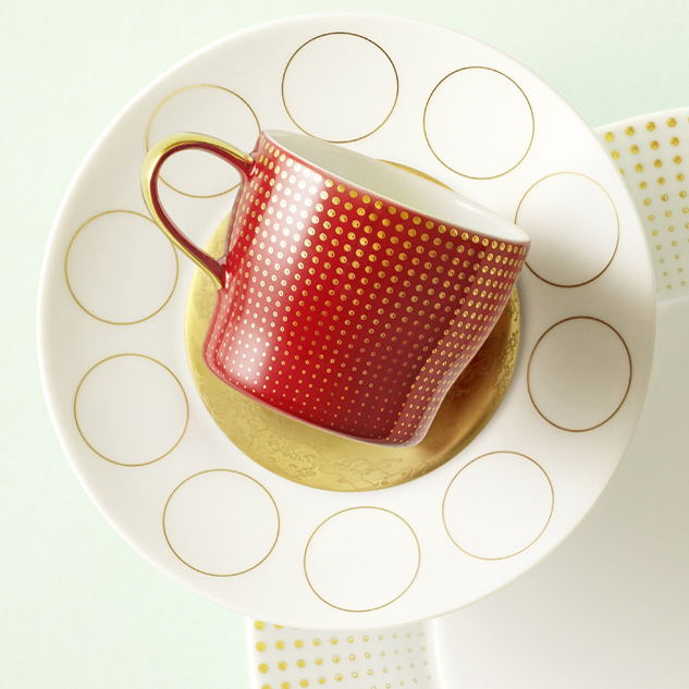 Rote Tasse mit goldenen Punkten auf verziertem Teller, zirkuläres Muster. Fürstenberg Porzellan.