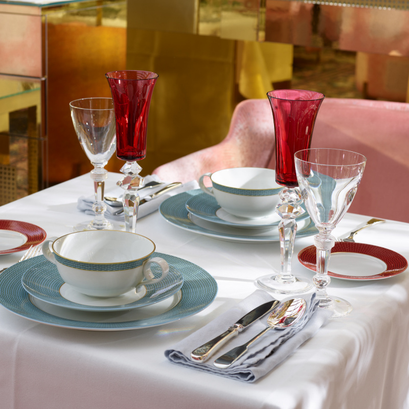 Elegantes Gedeck mit Gläsern, weißen Tassen und Teller auf weißer Tischdecke. Fürstenberg Porzellan.