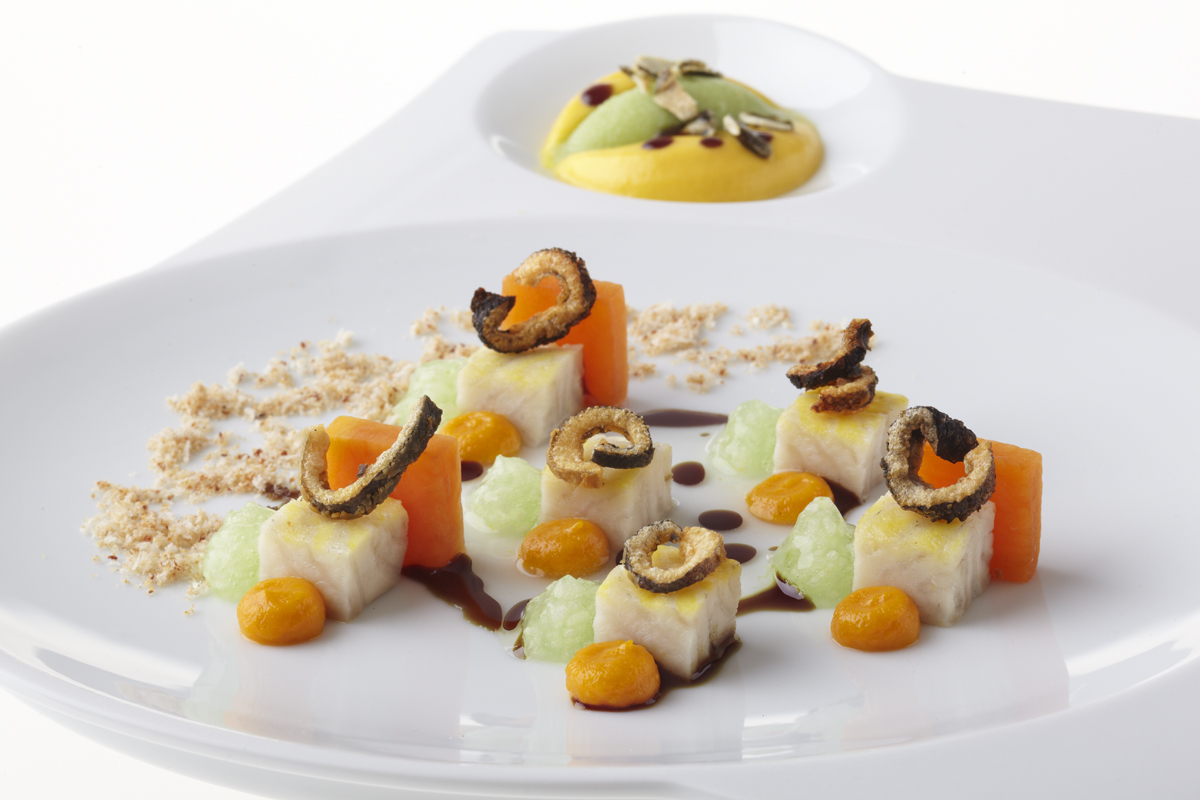 Würfel von Fisch und Gemüse, kunstvoll angerichtet auf einem modernen Teller. Fürstenberg Porzellan.