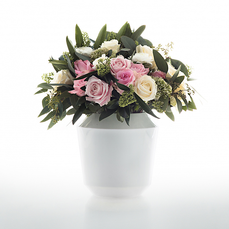 Vase hält Blumenstrauß mit rosa, weißen Rosen; dekoriert mit grünen Blättern. Fürstenberg Porzellan.