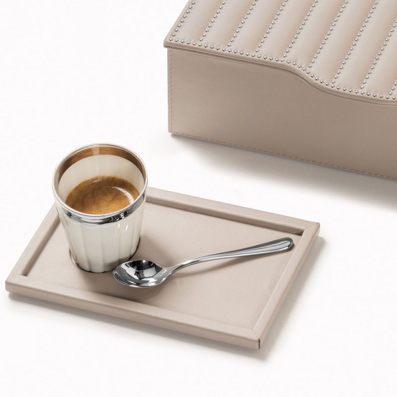 Espresso in Porzellantasse steht auf Leder-Tablett neben silbernem Löffel und Box. Fürstenberg Porzellan.