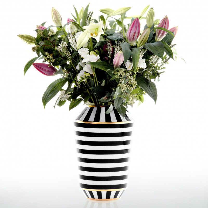 Gestreifte Vase hält bunte Blumen in Blüte, elegante Präsentation. Fürstenberg Porzellan.