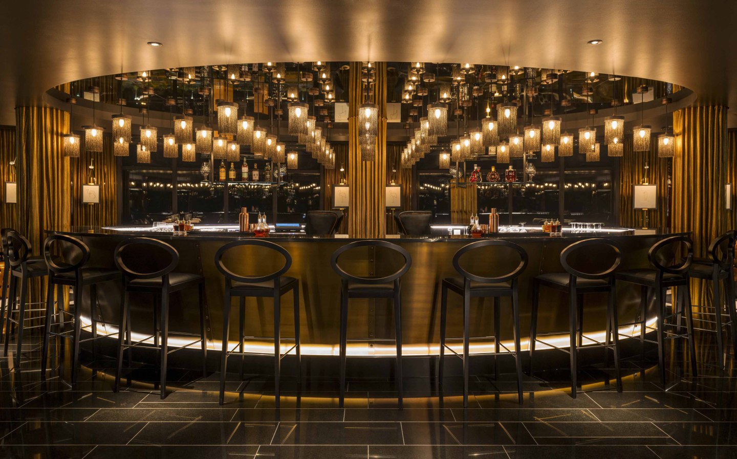 Barhocker umgeben goldene Bar mit hängenden Lampen in luxuriöser Umgebung. Fürstenberg Porzellan.