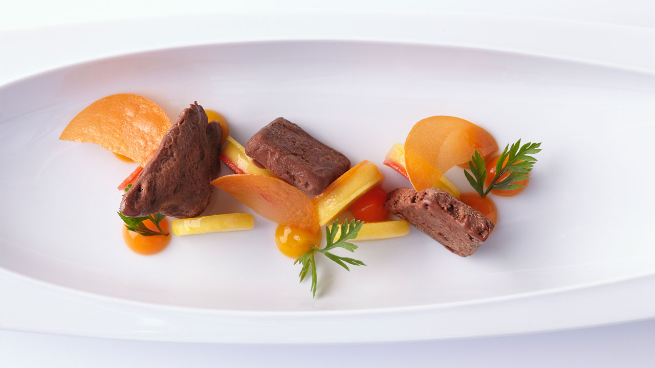 Edle Dessert-Präsentation mit Schokoladenmousse, Obstscheiben und Kräuterdekoration auf Porzellanteller. Fürstenberg Porzellan.