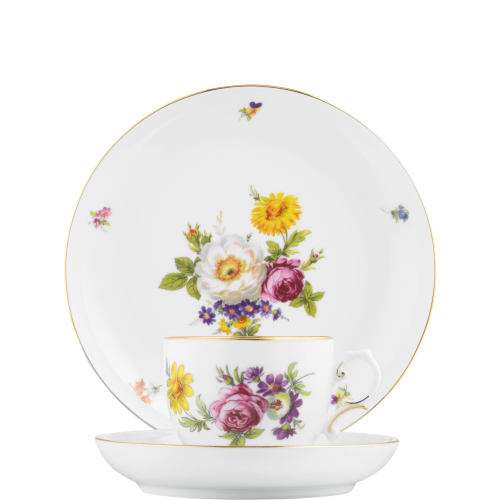 Tasse mit Blumenmuster steht auf Untertasse, vor passendem Teller platziert. Fürstenberg Porzellan.