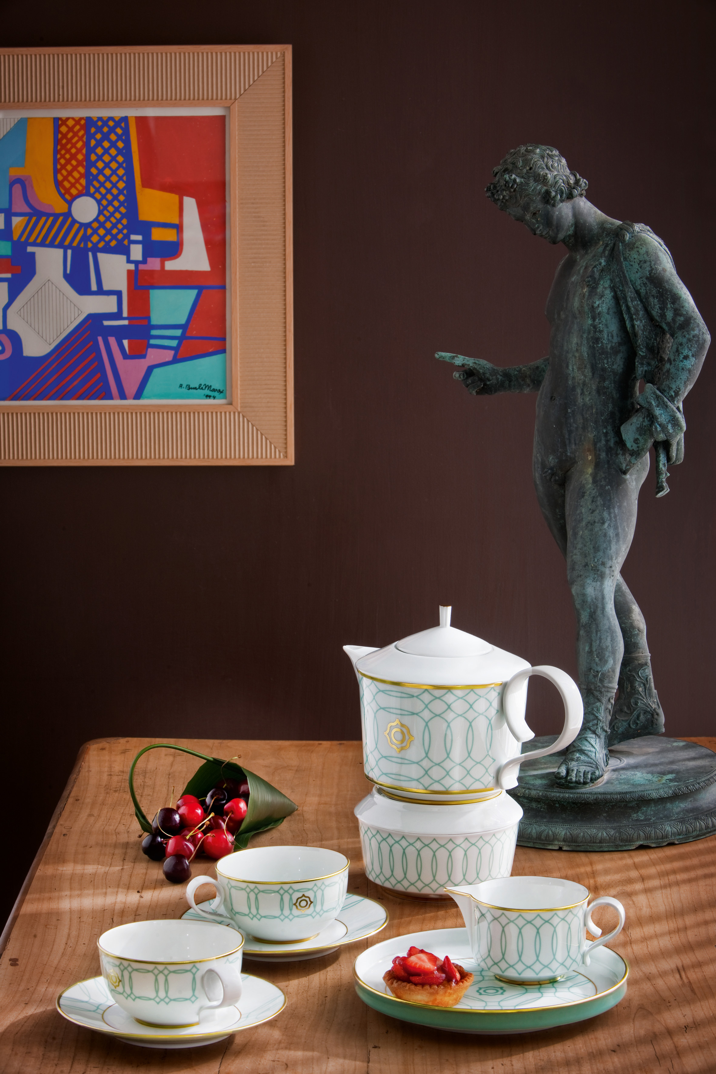 Porzellan-Teeservice, elegant auf Holztisch mit Statue und abstraktem Gemälde. Fürstenberg Porzellan.