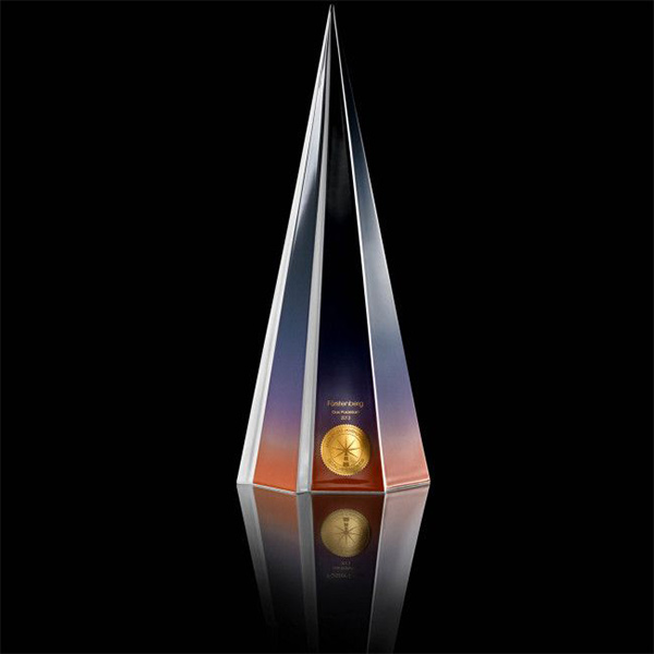 Glasstatue zeigt schillernde Farben mit Inschrift "Fürstenberg CO-COON", goldene Medaille darunter. Fürstenberg Porzellan.