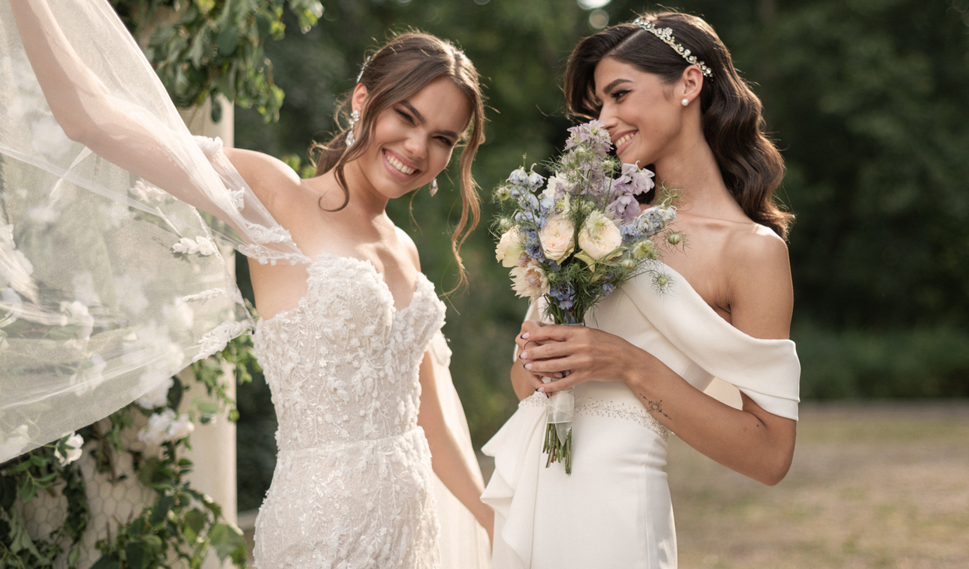 Zwei lachende Frauen in Brautkleidern, eine hält Blumenstrauß, draußen stehend. Fürstenberg Porzellan.