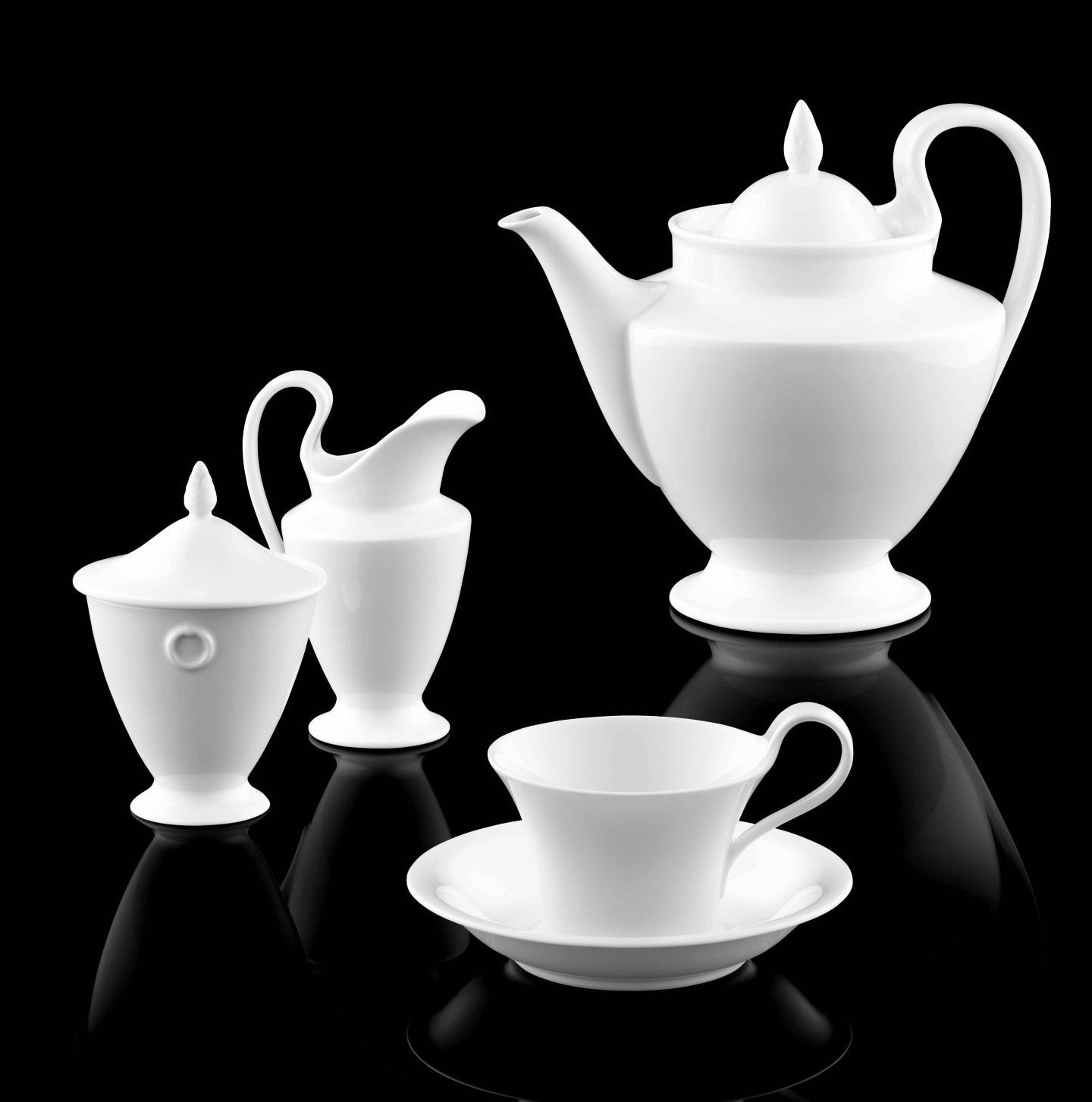 Teekanne, Zuckerdose, Milchkännchen und Tasse aus weißem Porzellan auf schwarzem Hintergrund. Fürstenberg Porzellan.