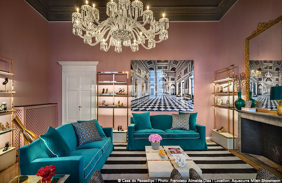Kronleuchter hängt über türkisfarbenen Sofas, Tapeten rosa, Bild großer Palast im Hintergrund. Fürstenberg Porzellan.