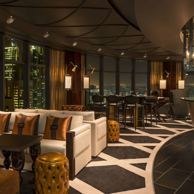 Luxuriöse Hotelbar bei Nacht mit Sofas, Hockern, hohen Fenstern, Stadtblick. Fürstenberg Porzellan.