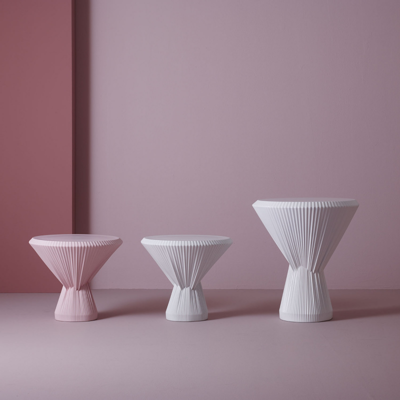 Drei konische, geriffelte Hocker in Rosa und Weiß stehen nebeneinander. Fürstenberg Porzellan.
