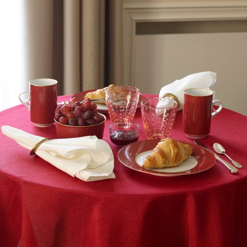 Frühstückstisch mit rotem Geschirr, Croissants, Trauben, Saftgläsern und Servietten. Fürstenberg Porzellan.