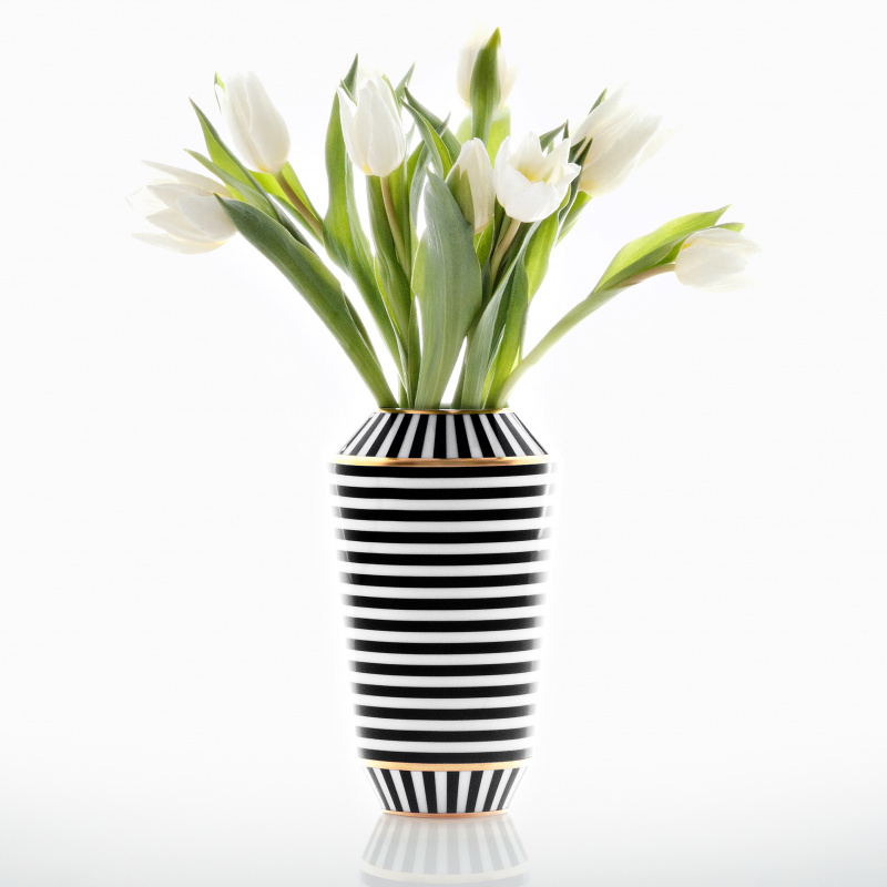 Schwarz-weiß gestreifte Vase mit weißen Tulpen, dekorativ arrangiert. Fürstenberg Porzellan.