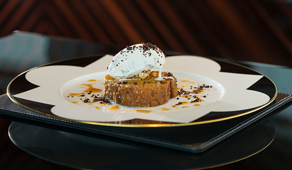 Kuchenstück mit Sahne auf dekorativem Porzellanteller, serviert im eleganten Ambiente. Fürstenberg Porzellan.