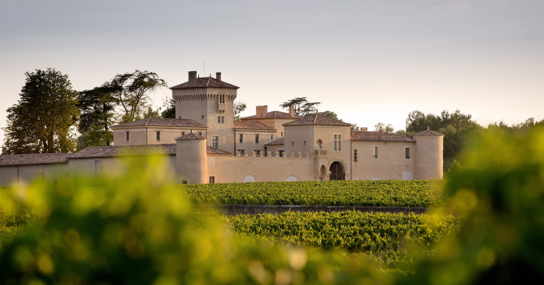 Historisches Schloss steht inmitten von grünen Weinbergen, umgeben von Bäumen. Fürstenberg Porzellan.