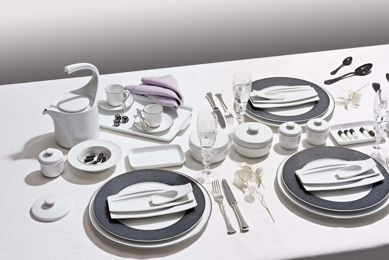 Elegantes Geschirr-Set mit Besteck, Tassen, Gläsern und Serviette auf weißer Tischdecke. Fürstenberg Porzellan.