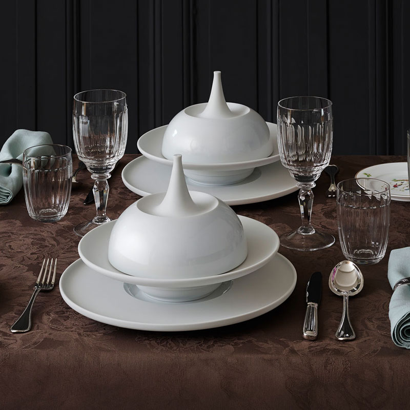 Weißes Porzellan-Geschirr mit Haube, elegant gedeckter Tisch, braunes Tischtuch. Fürstenberg Porzellan.