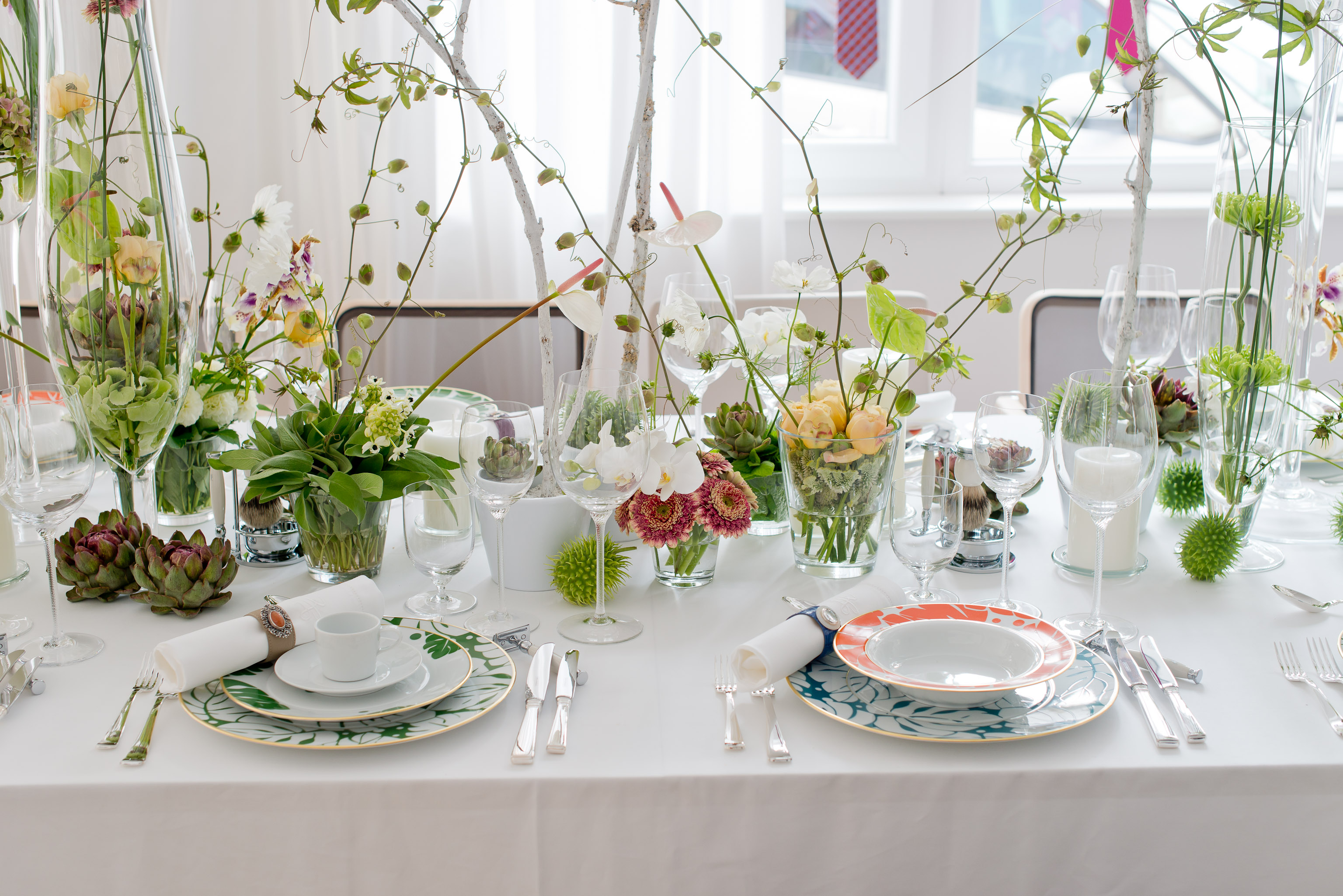 Elegant gedeckter Tisch mit Porzellantellern, Besteck und glasierter Blumendekoration. Fürstenberg Porzellan.