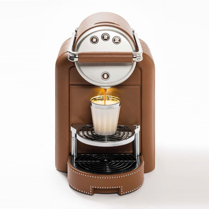 Braune Kaffeemaschine mit silbernem Bedienteil, brüht Kaffee in silberne Tasse. Fürstenberg Porzellan.