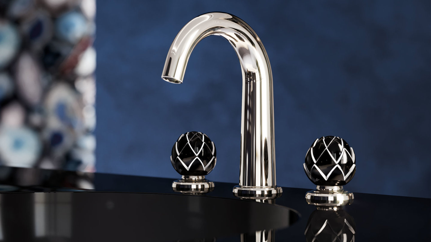 Chromfarbener Wasserhahn mit schwarzen, dekorativen Griffen auf dunklem Untergrund. Fürstenberg Porzellan.