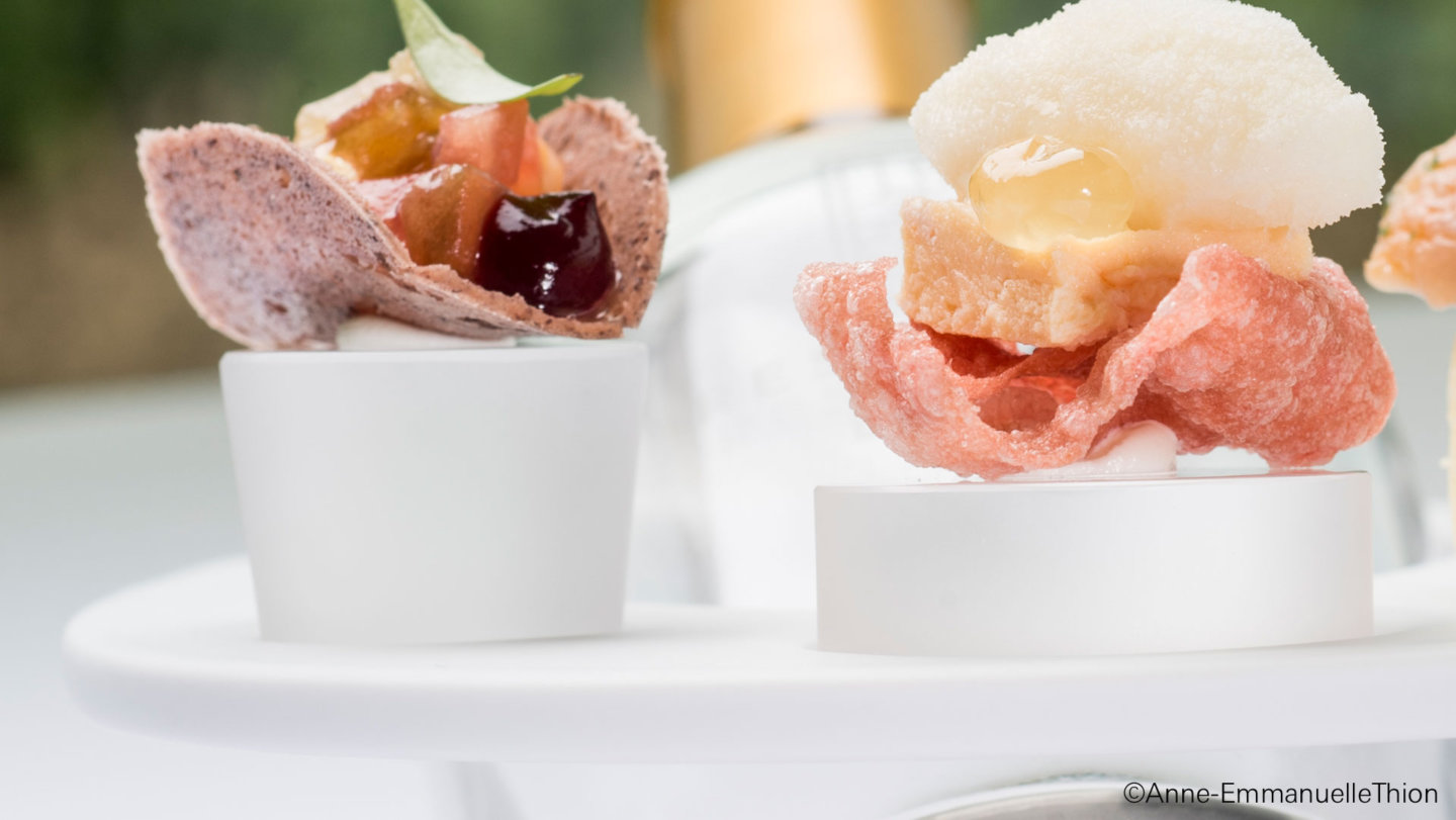Zwei kreative Amuse-Bouches auf weißen Porzellantellern, begleitet von weißen Sockeln. Fürstenberg Porzellan.
