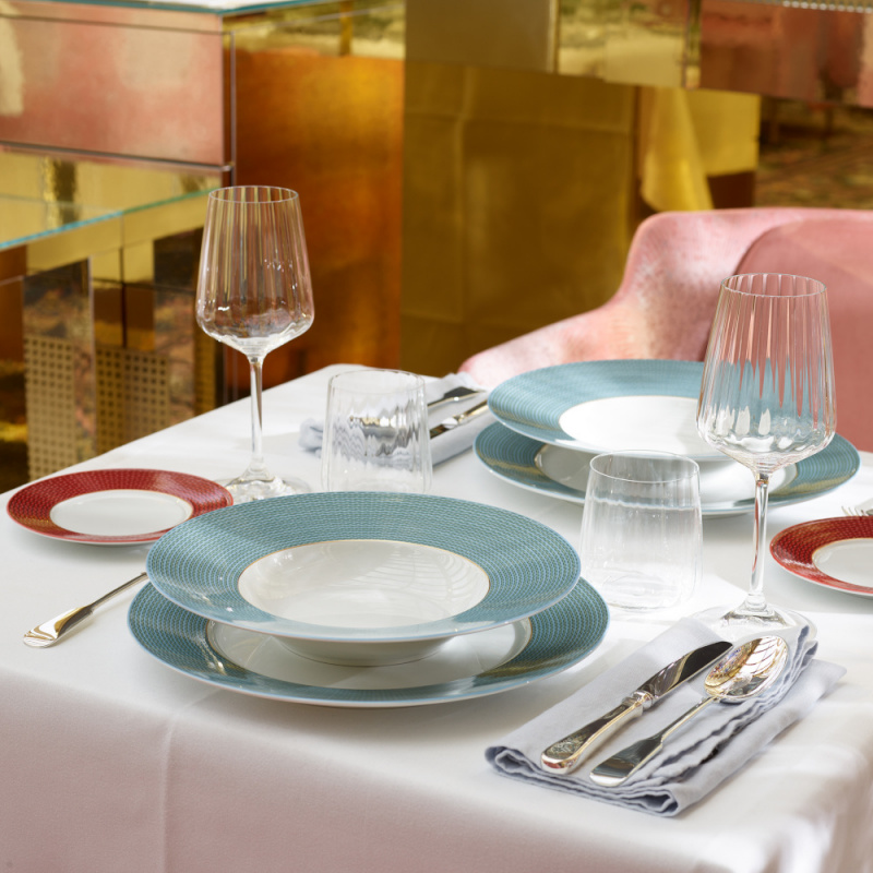 Eleganter, gedeckter Tisch mit buntem Geschirr und Gläsern, umgeben von luxuriösem Ambiente. Fürstenberg Porzellan.
